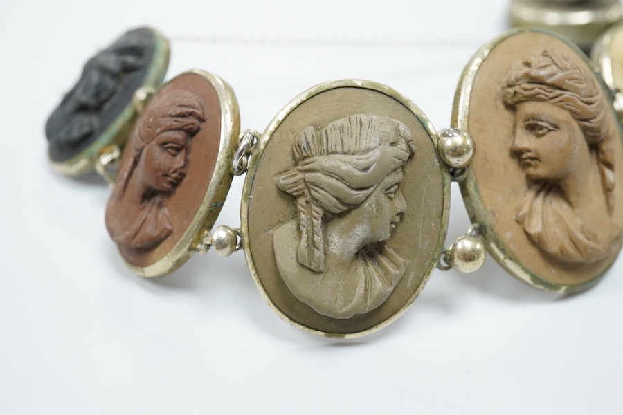 A Victorian base metal bracelet, set with seven graduated lava cameos, carved with the busts of lady's to dexter and sinister, approximately 16.5cm.